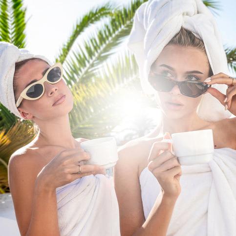 Women in towels and sunglasses enjoying a moment of post-facial relaxation — capturing Exoceuticals®’ approach to skincare as both science and self-care.