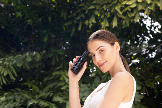 A sunlit model holding Exoceuticals® skincare outdoors — illustrating the brand’s protective and restorative approach to reversing sun damage.