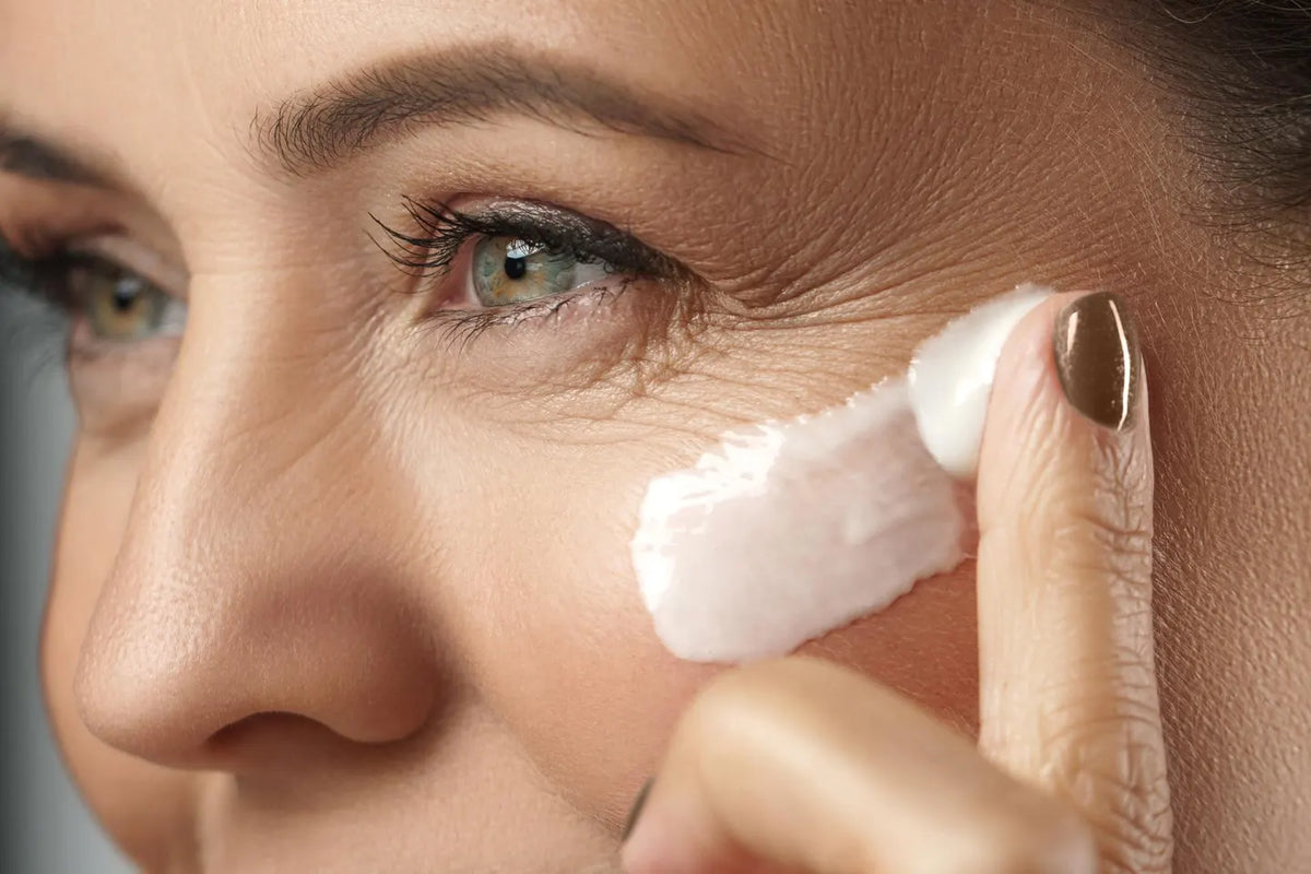A woman applying under-eye cream with gentle pressure — illustrating targeted skincare in Forbes’ feature on exosomes as a next-gen beauty breakthrough.