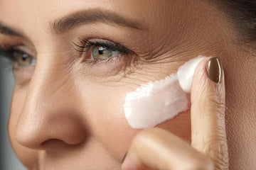 A woman applying under-eye cream with gentle pressure — illustrating targeted skincare in Forbes’ feature on exosomes as a next-gen beauty breakthrough.