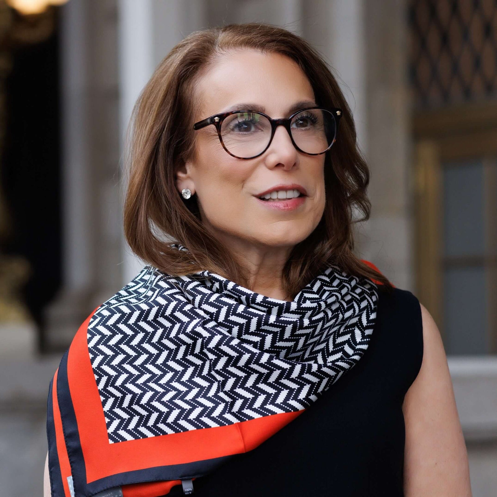 Dr. Robin L. Smith, partner at Exoceuticals®, standing outside in a patterned scarf and glasses.