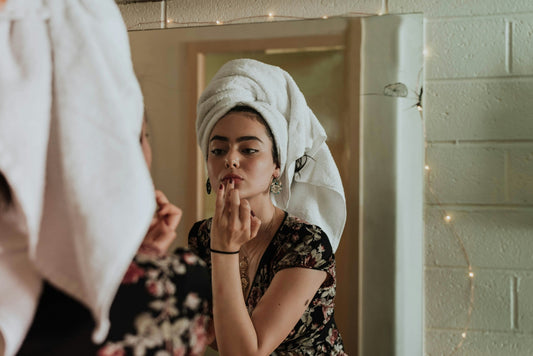 Woman in a morning skincare ritual applying product to her face — illustrating ice-based skincare timing as explored in daily routine features.