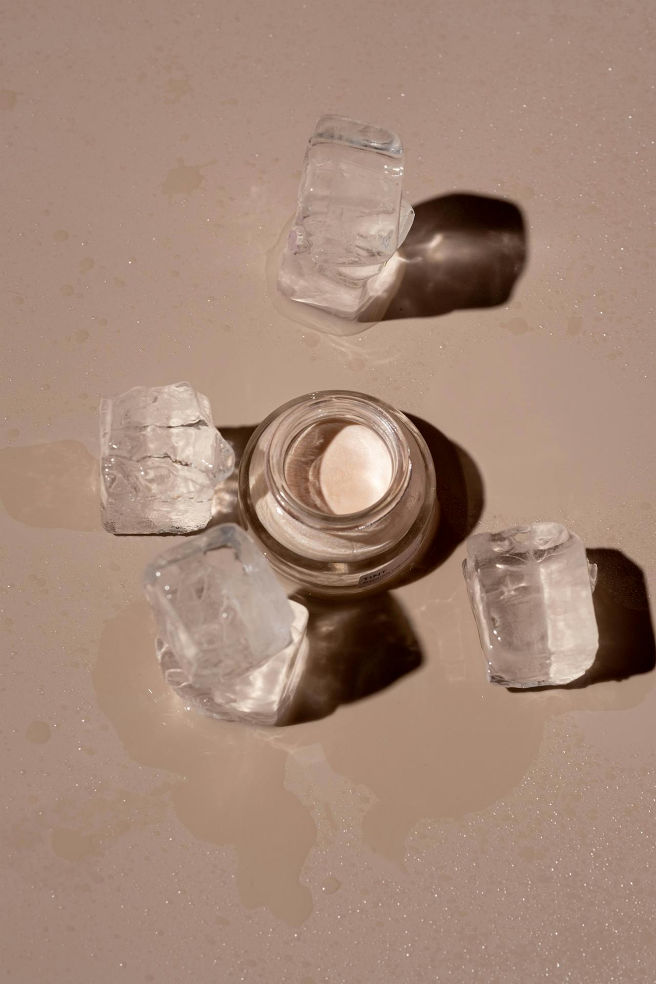 Cold meets care: a minimalist still life of ice and skincare captures the elemental beauty of cryotherapy’s role in calming and reviving the skin.